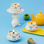 Illustrated ceramic cup scented candle with flame on a small saucer