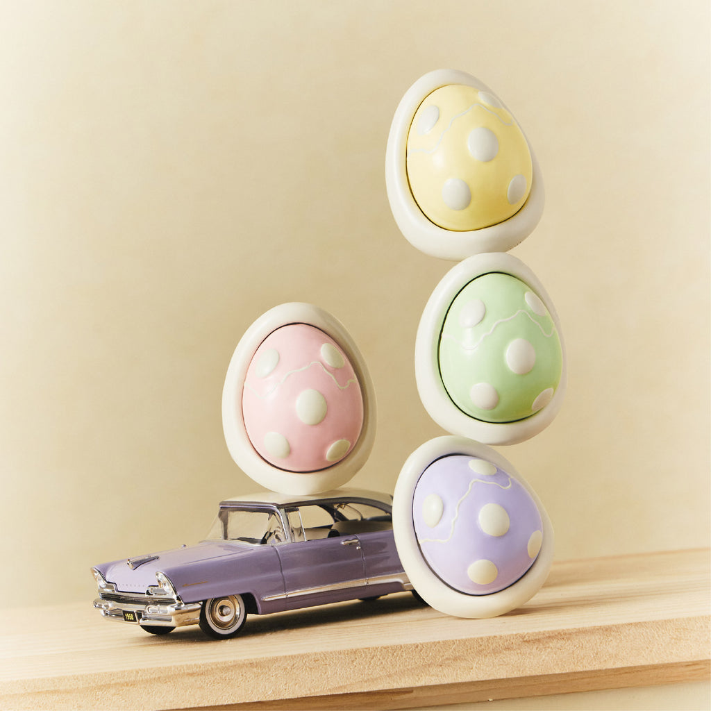 Car diffuser egg scent pods in pastel yellow, green, and purple with white holder