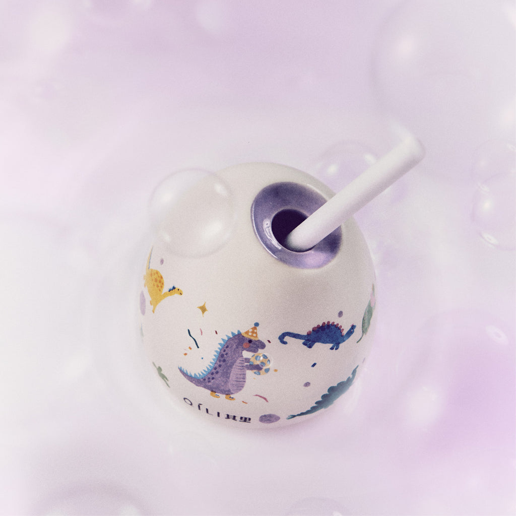 Close-up of dinosaur reed diffuser globe with purple scent holder opening and reeds