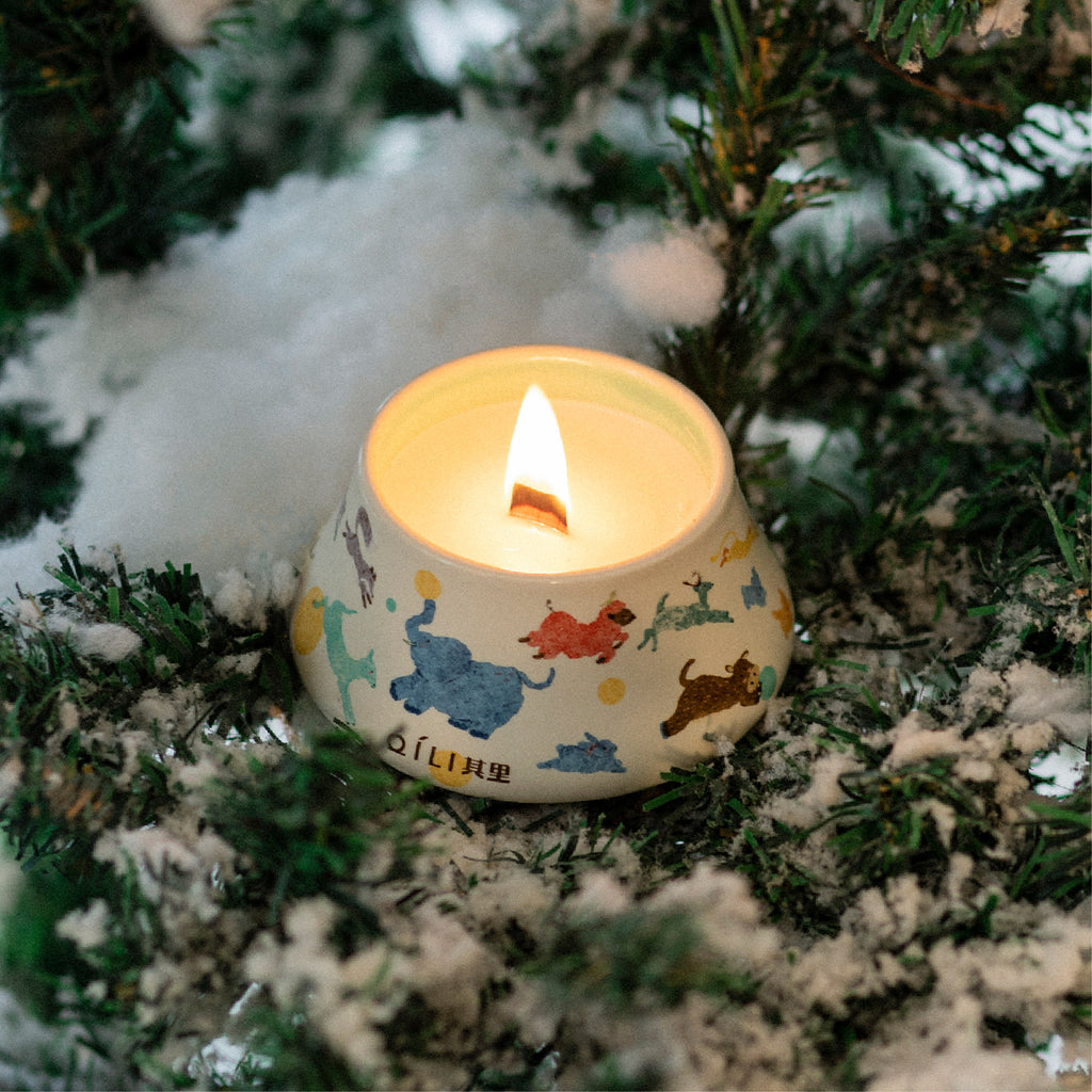 Scented candle in illustrated ceramic cup with flame and light smoke
