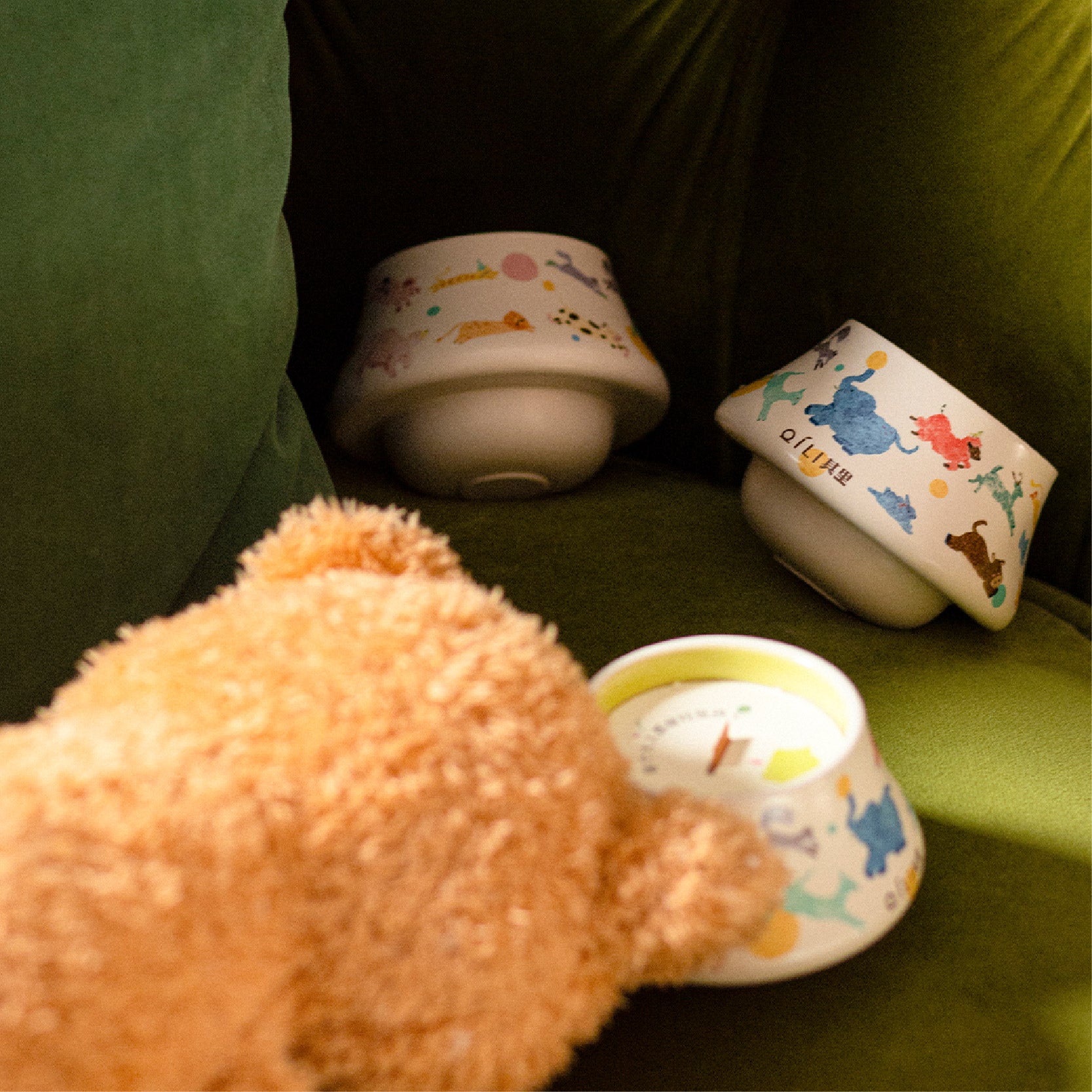 Scented candle in illustrated ceramic cup with matching lid on table