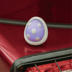 Purple egg-shaped car diffuser scent pod on red car surface