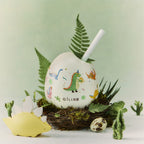 Dinosaur reed diffuser with white globe, straw reeds, and dinosaur-themed decor